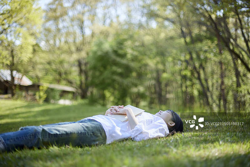 女人躺在初夏的森林中放松图片素材
