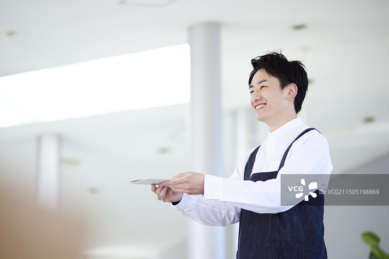 在咖啡馆工作的年轻日本男子图片素材