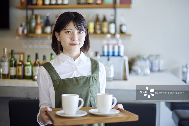 在咖啡馆工作的年轻日本女人图片素材