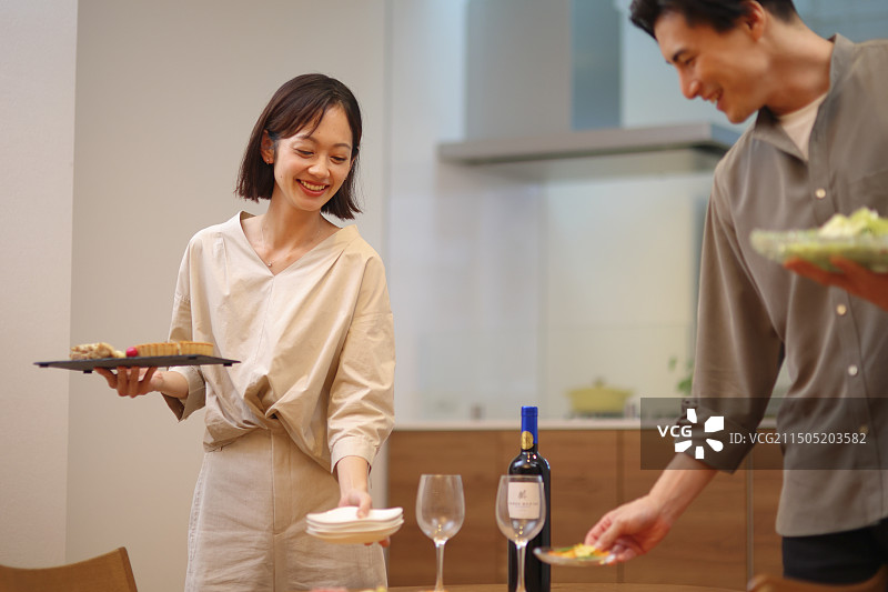 30多岁的夫妇在餐桌旁提供食物图片素材