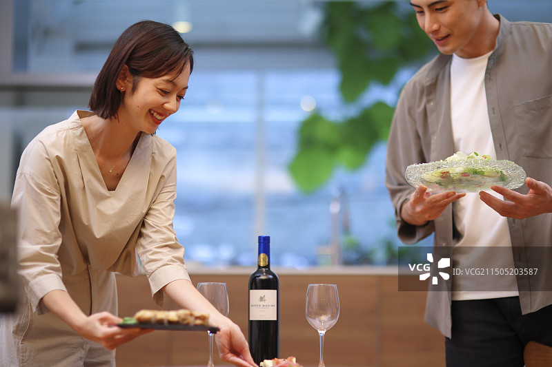 30多岁的夫妇在餐桌旁提供食物图片素材