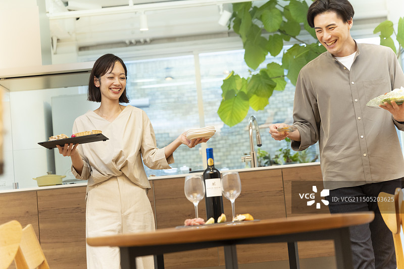 30多岁的夫妇在餐桌旁提供食物图片素材