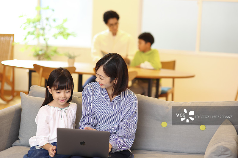 四口之家打开笔记本电脑和书籍图片素材