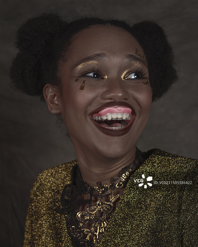 化妆、佩戴珠宝和假牙的美丽女人图片素材