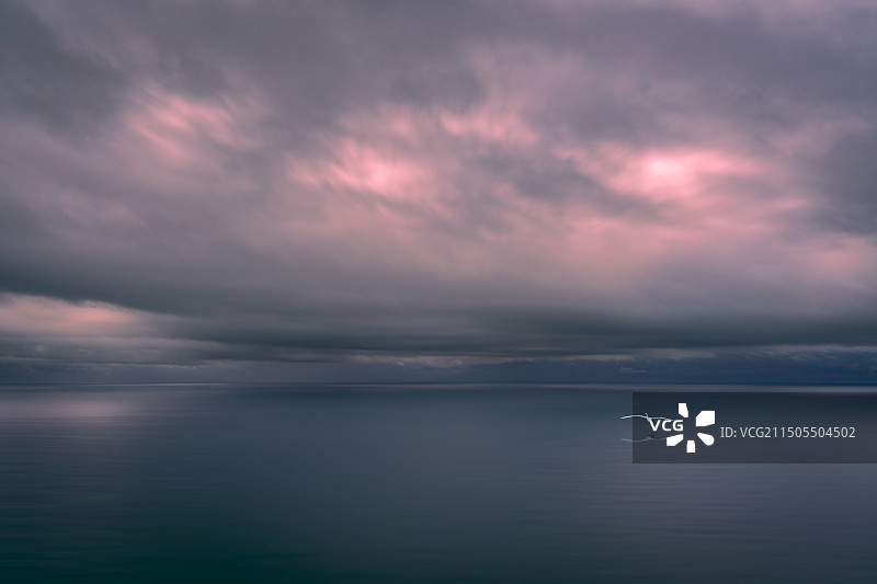 日落时海景映衬着戏剧性的天空图片素材