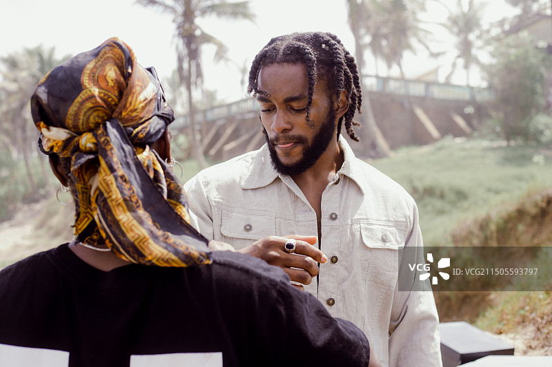 在加纳阿克拉与摄影师一起看照片的男模特时装拍摄图片素材