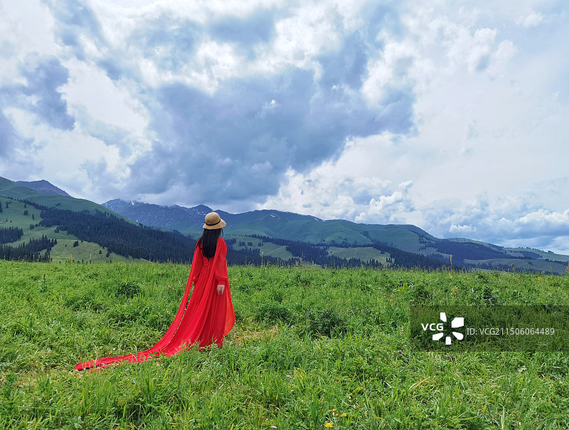 新疆那拉提草原上的红裙女子图片素材