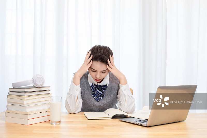 室内一个疲惫的中国女大学生图片素材