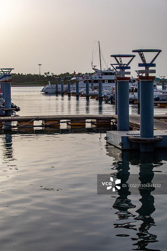 夏天清晨的山东日照万平口海洋公园万平口海洋大桥潮汐塔帆赛基地游艇船与日照城市建筑景观图片素材