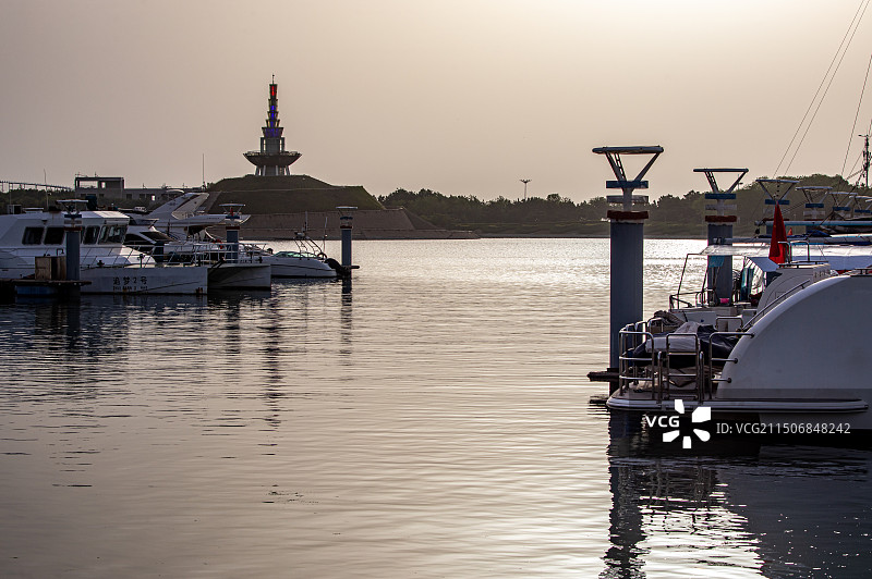 夏天清晨的山东日照万平口海洋公园万平口海洋大桥潮汐塔帆赛基地游艇船与日照城市建筑景观图片素材