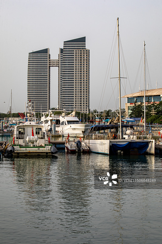 夏天清晨的山东日照万平口海洋公园万平口海洋大桥潮汐塔帆赛基地游艇船与日照城市建筑景观图片素材