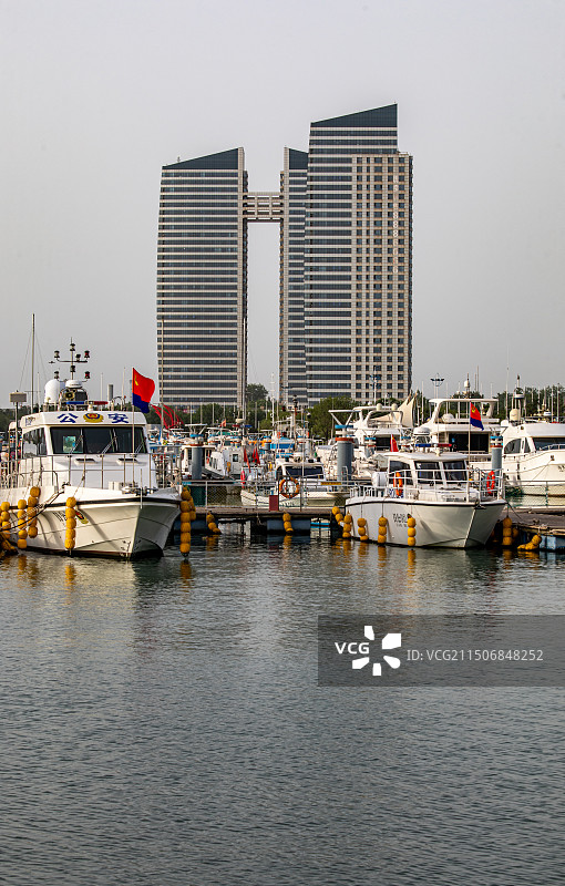 夏天清晨的山东日照万平口海洋公园万平口海洋大桥潮汐塔帆赛基地游艇船与日照城市建筑景观图片素材