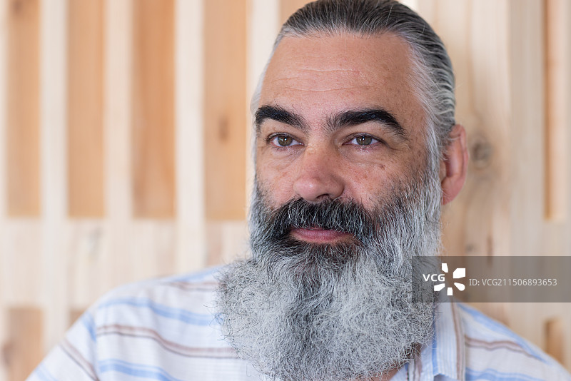 穿着休闲衬衫的年长白人，留着灰色胡须，若有所思图片素材