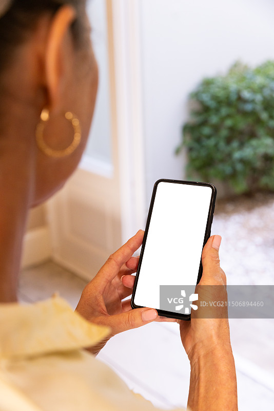 手持智能手机，女人在家庭环境中看空白屏幕，有复制空间图片素材