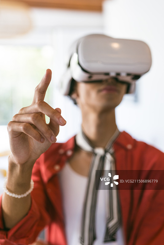 戴VR头显的年轻人在家与虚拟环境互动图片素材