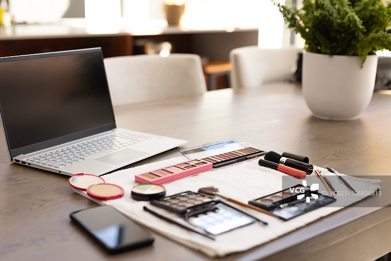 化妆工具和笔记本电脑在桌子上，准备在家进行在线美容教程图片素材
