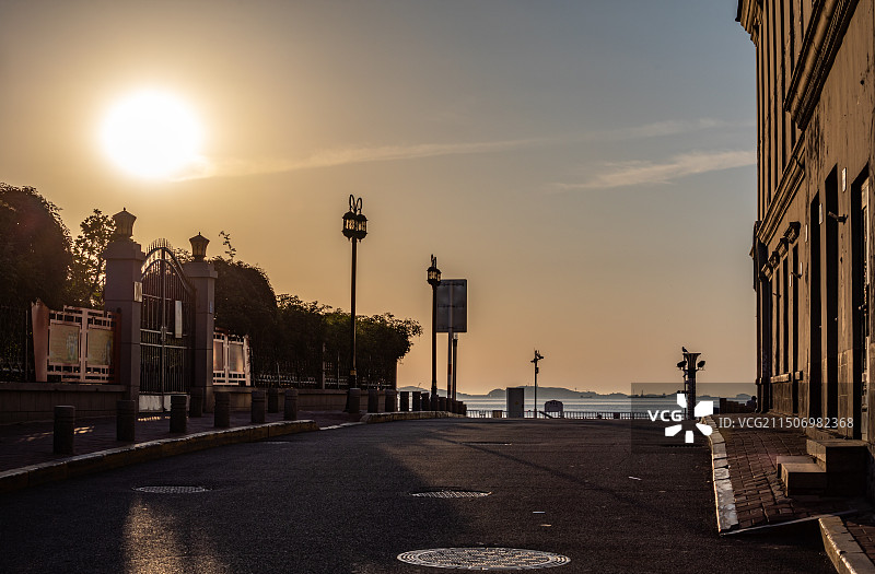 夏日清晨日出中的山东烟台朝阳街海岸街烟台市第一海水浴场山海路人景点景观剪影特写镜头图片素材