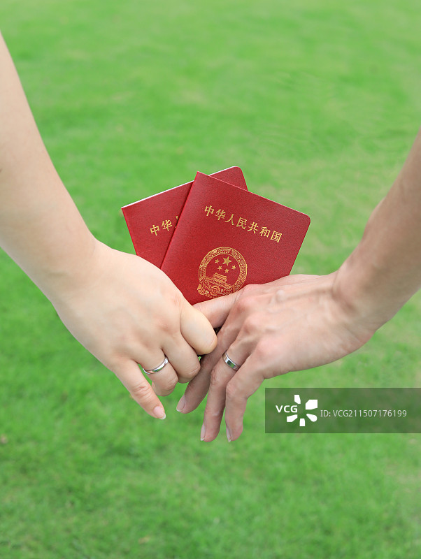 两个人手牵手拿着结婚证的幸福婚姻图片图片素材