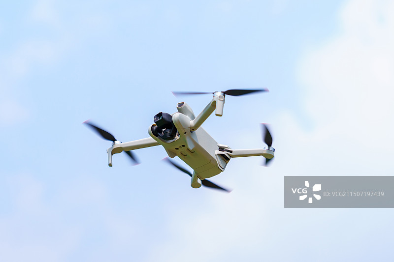 无人机在蓝天下飞行的低角度视图图片素材