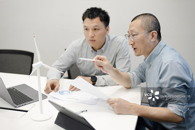 工程师在会议室研究讨论新能源技术图片素材