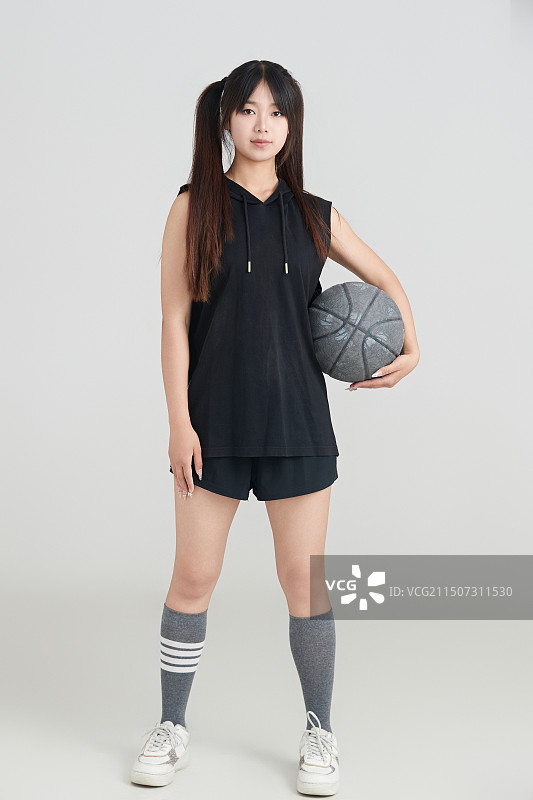 白色背景下的年轻女孩和篮球图片素材