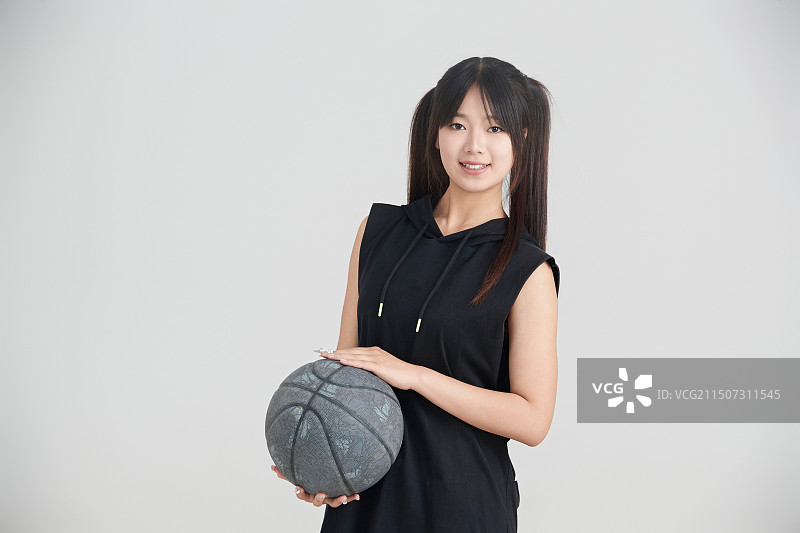 白色背景下的年轻女孩和篮球图片素材