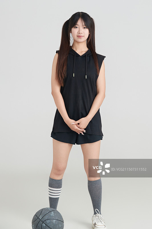 白色背景下的年轻女孩和篮球图片素材