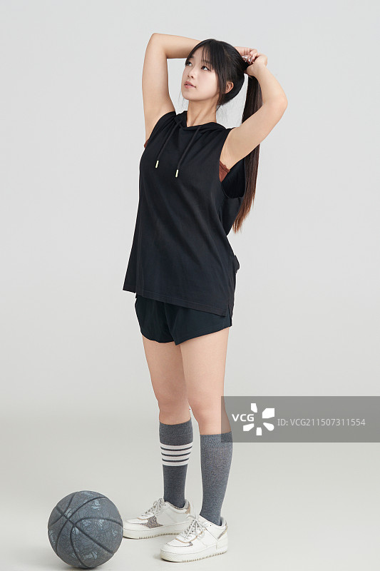 白色背景下的年轻女孩和篮球图片素材