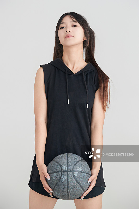 白色背景下的年轻女孩和篮球图片素材