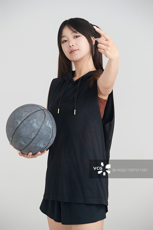 白色背景下的年轻女孩和篮球图片素材