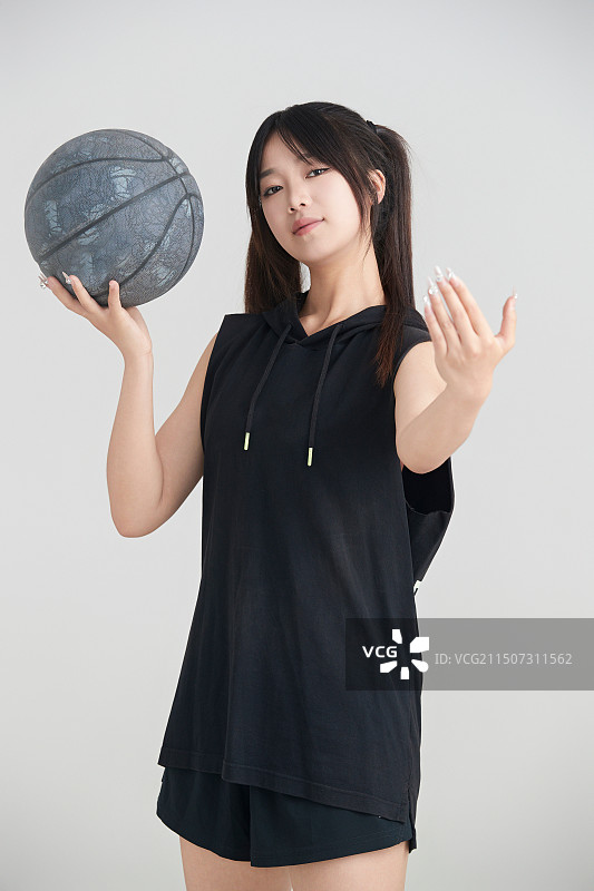 白色背景下的年轻女孩和篮球图片素材