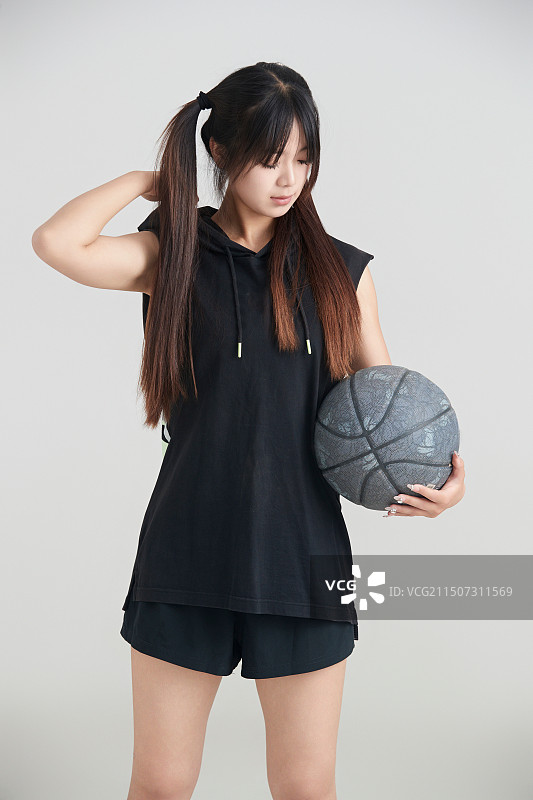 白色背景下的年轻女孩和篮球图片素材