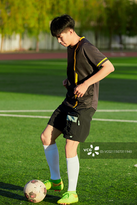 户外足球场上踢足球的运动员图片素材