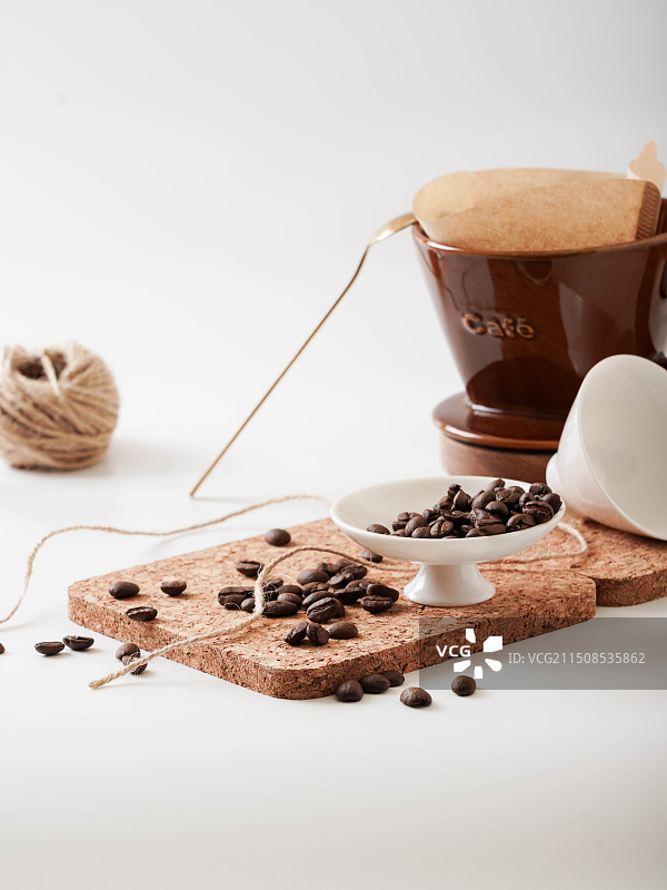 一碟咖啡豆和咖啡滤杯图片素材