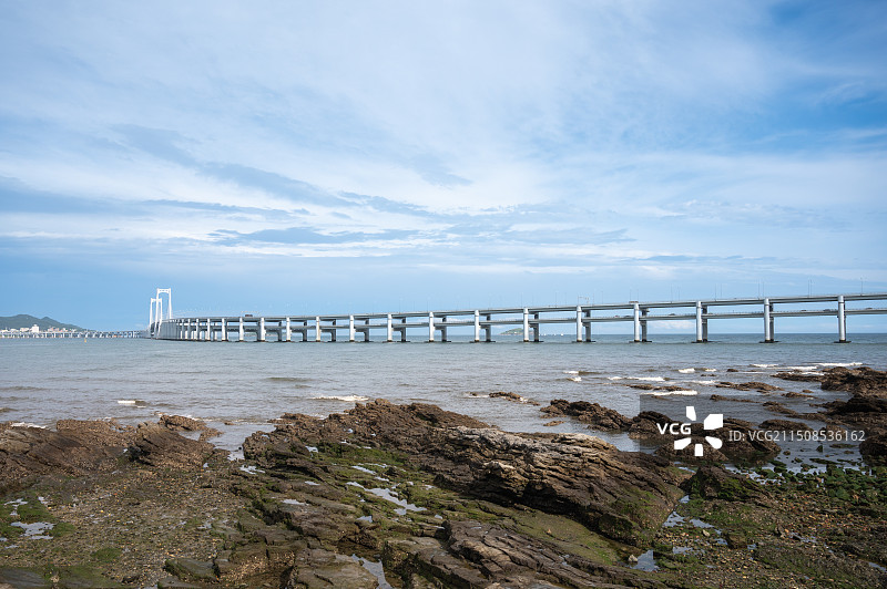 蓝天白云下的城市天际线，大连星海湾城市景观，现代海滨都市度假风景图片素材