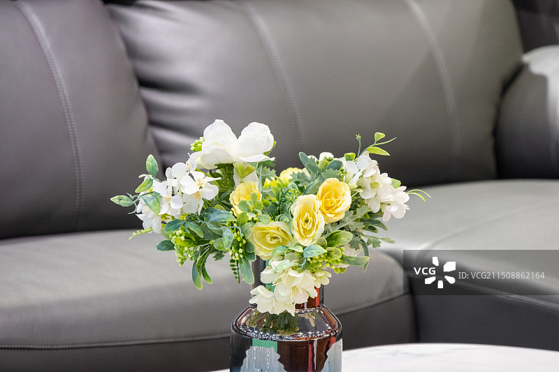 客厅布置皮沙发与茶几上的仿真花图片素材