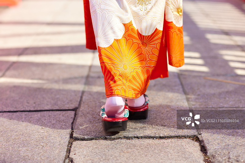 亚洲女性身穿和服走在人行道上图片素材