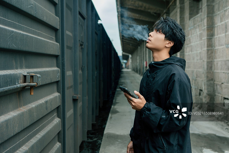 铁路火车前，旅行者抽烟的肖像图片素材