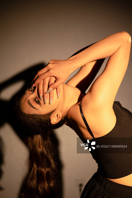 灯光下跳现代舞的美女表演者图片素材