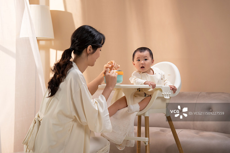 青年妈妈喂宝宝吃饭图片素材