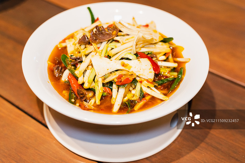 中式传统美食桌上盘子里的火爆脆爽大火炒黄喉腰片和蒜薹特写图片素材