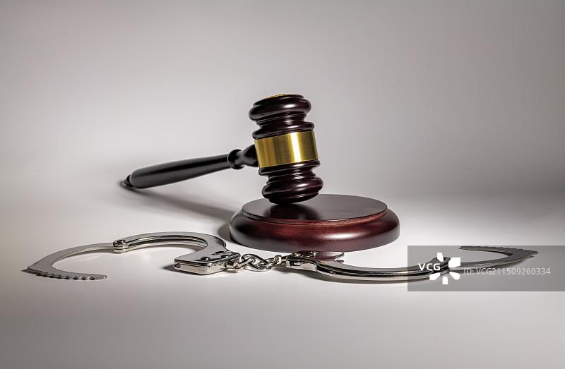 白色背景上的法槌和手铐的特写镜头图片素材