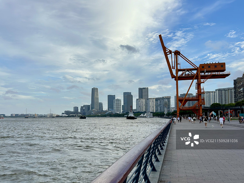 上海徐汇滨江风景，多云天空下的黄浦江和远处的城市天际线图片素材