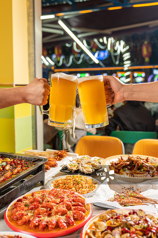 餐厅里拿着啤酒的人的手啤酒干杯图片素材