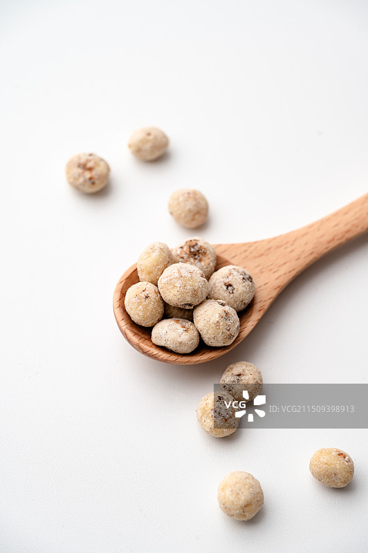 白色背景，放在勺子里的去皮油莎豆图片素材