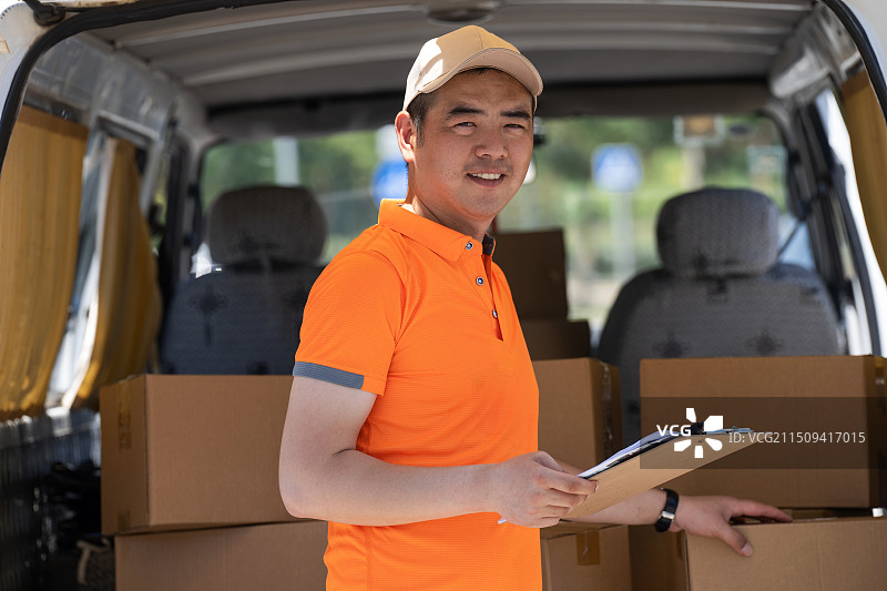 快递人员拿着配送记录表图片素材