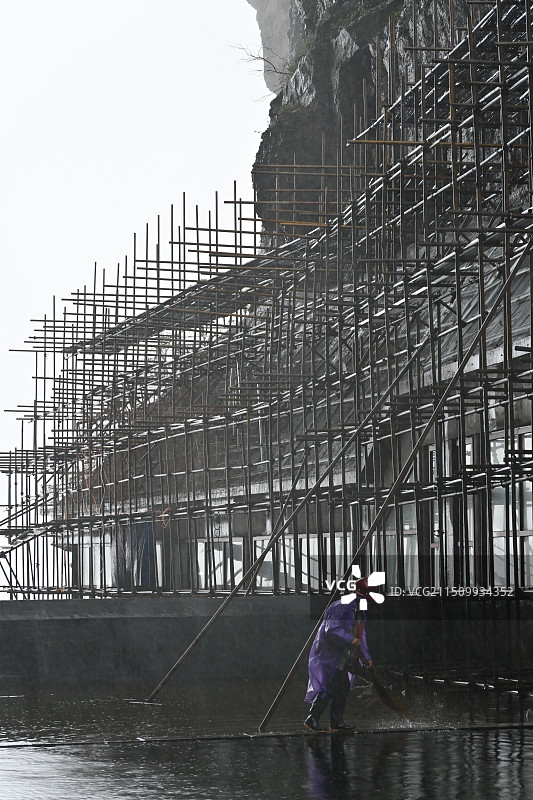 脚手架下雨天中干活的农民工图片素材