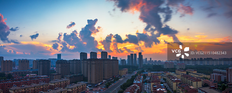 乌云难遮朝霞的光辉-夏天清晨城市上空的上演云遮日的梦幻云景24.08图片素材