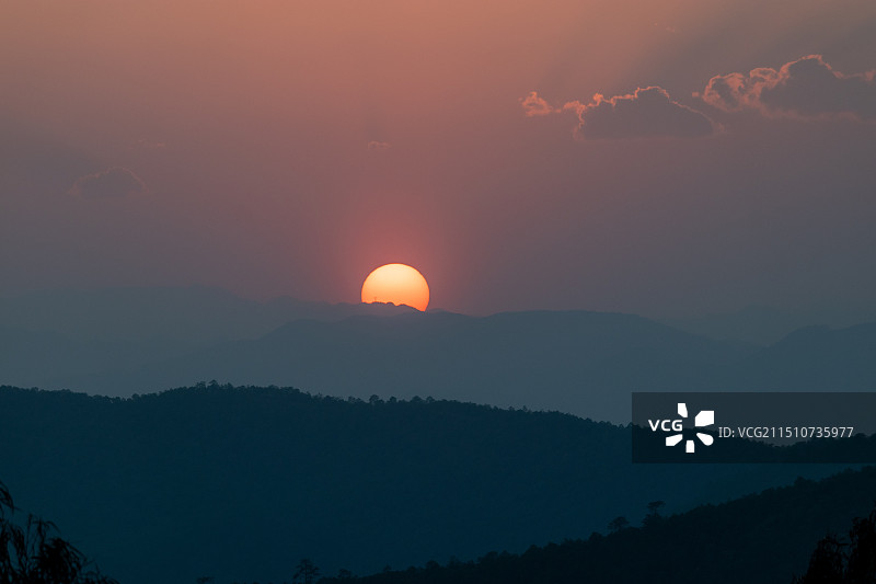 中国云南楚雄永仁县方山森林度假区，日落时分的夕阳与远山山脉风景图片素材