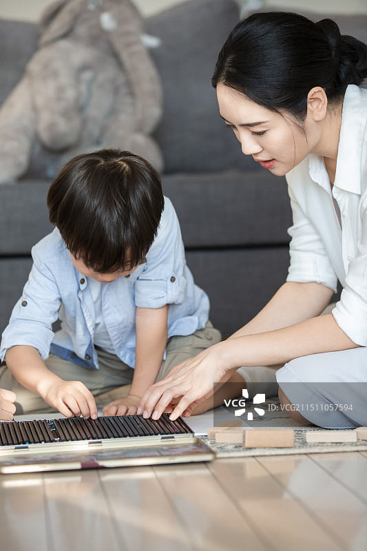 妈妈和儿子两个人在客厅一起画画图片素材